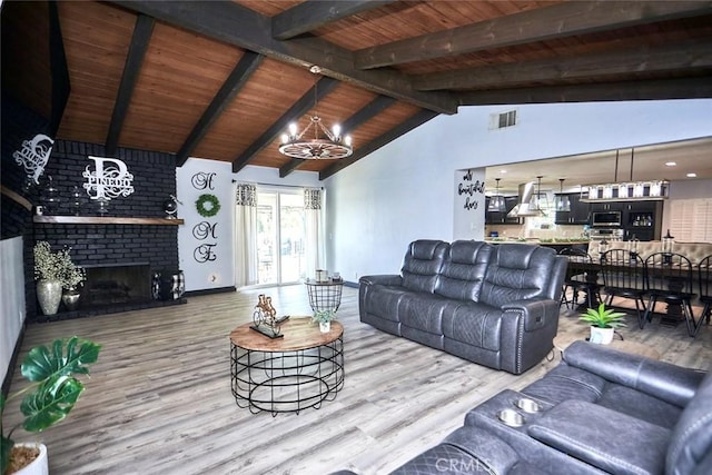 living room with wooden ceiling, a brick fireplace, lofted ceiling with beams, a notable chandelier, and hardwood / wood-style floors