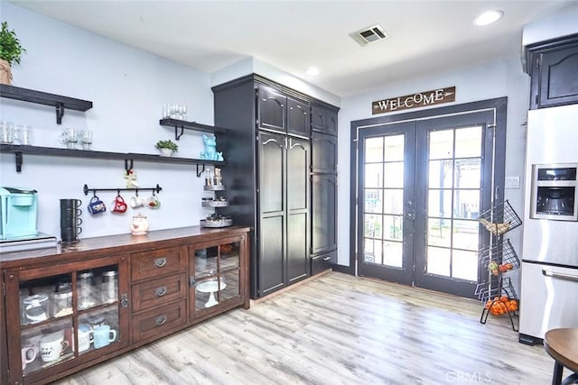 kitchen with french doors, white fridge with ice dispenser, and light wood-type flooring