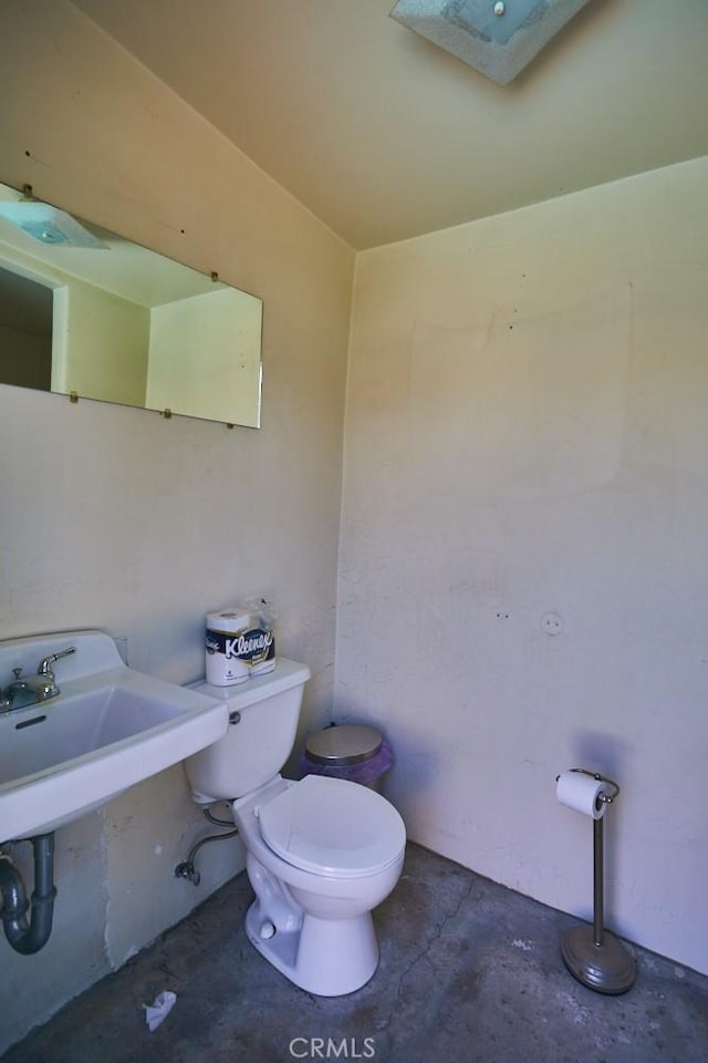 bathroom with toilet and concrete flooring