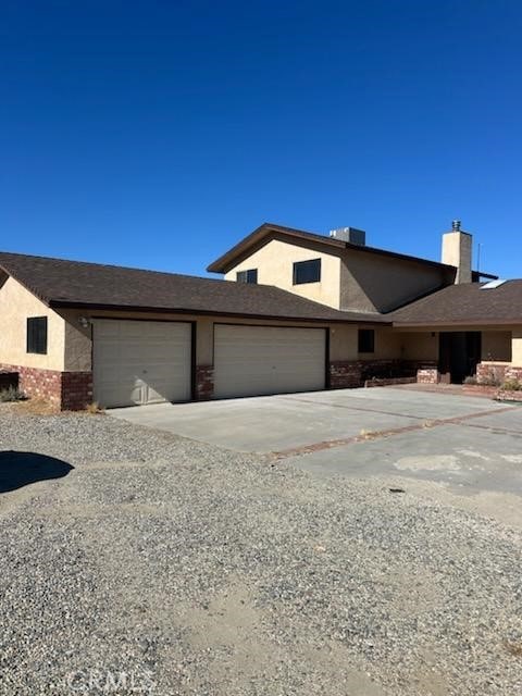 view of front of home with cooling unit and a garage