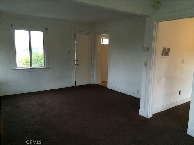 spare room with dark carpet