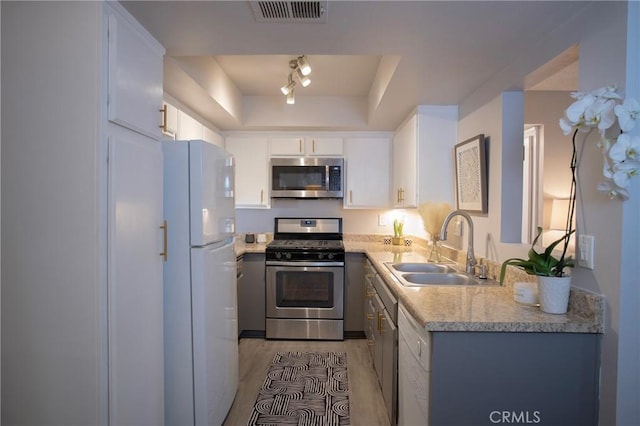 kitchen featuring white cabinets, light hardwood / wood-style floors, sink, and stainless steel appliances