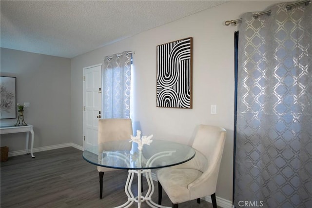 dining space featuring hardwood / wood-style flooring and a textured ceiling