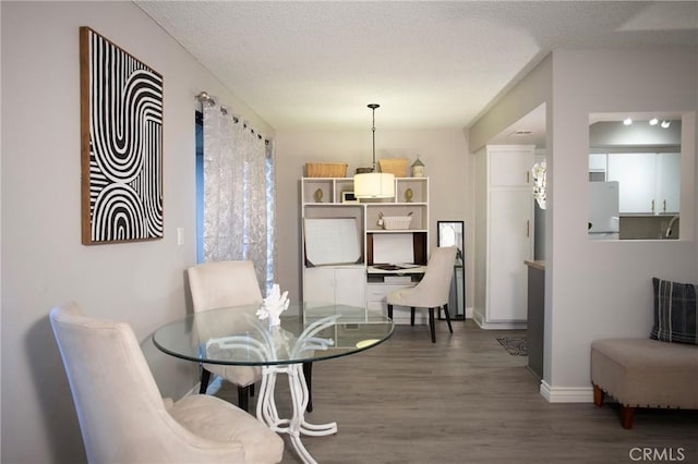 dining space featuring dark hardwood / wood-style floors and a textured ceiling