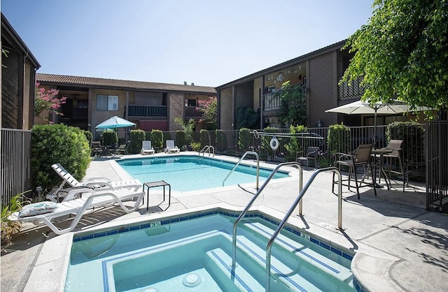 view of swimming pool with a community hot tub and a patio