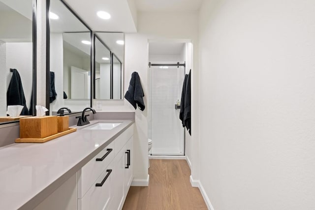 bathroom with walk in shower, toilet, vanity, and hardwood / wood-style flooring