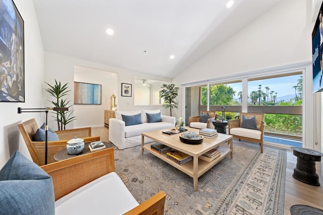 living room featuring ceiling fan, light hardwood / wood-style flooring, and high vaulted ceiling