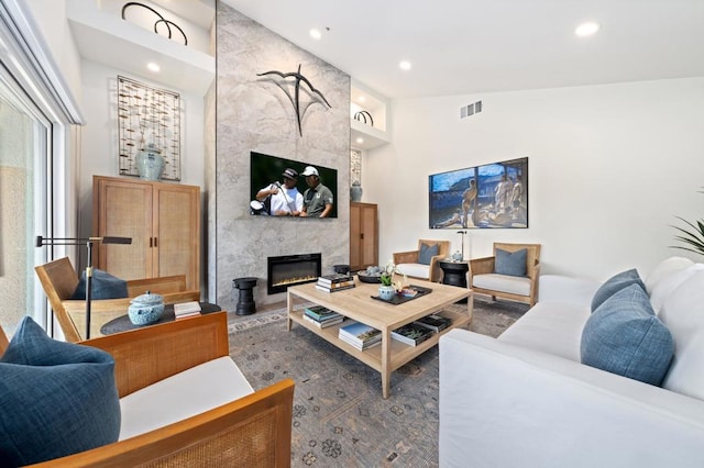 living room with high vaulted ceiling and a premium fireplace