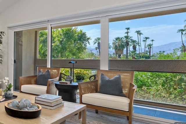 sunroom / solarium with a mountain view and lofted ceiling