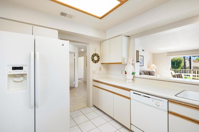 kitchen with sink, white cabinets, light tile patterned flooring, and white appliances