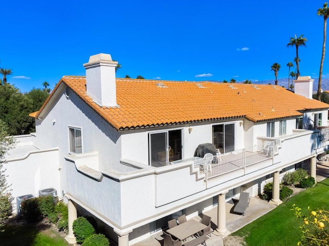 back of house with a balcony and a patio