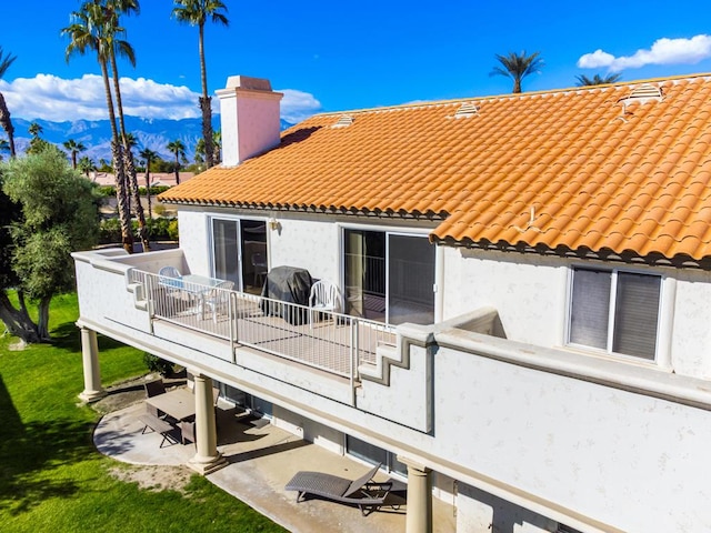 rear view of house with a patio and a balcony