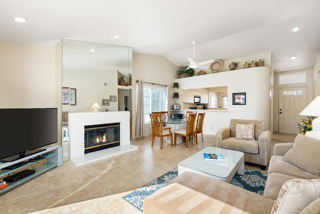 tiled living room with a tiled fireplace and lofted ceiling