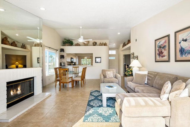 tiled living room with ceiling fan, a fireplace, and lofted ceiling