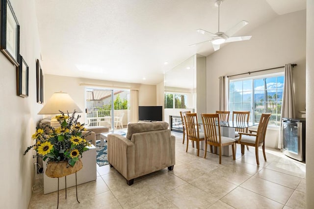 tiled living room featuring wine cooler, ceiling fan, and lofted ceiling