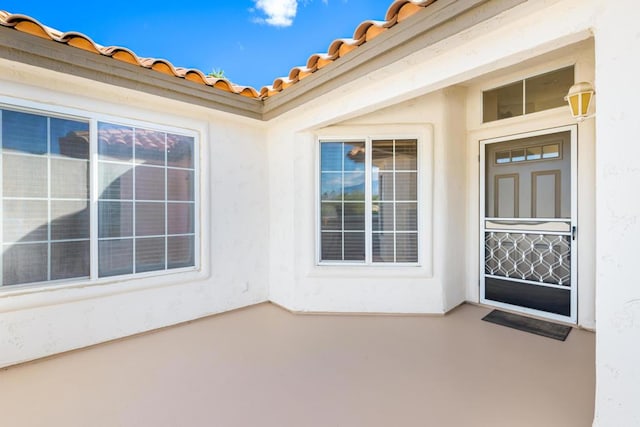 view of exterior entry with a patio area