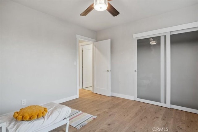 bedroom with ceiling fan, a closet, and light hardwood / wood-style floors