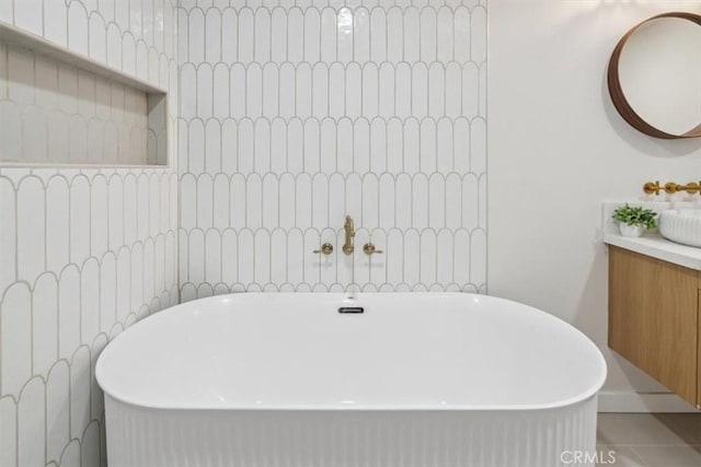 bathroom with vanity, tile patterned flooring, and a washtub