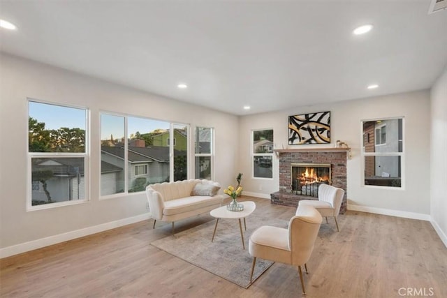 living room featuring a brick fireplace and light hardwood / wood-style floors