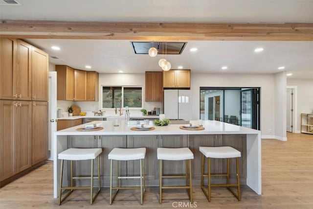 kitchen featuring white refrigerator, a large island, and a breakfast bar area