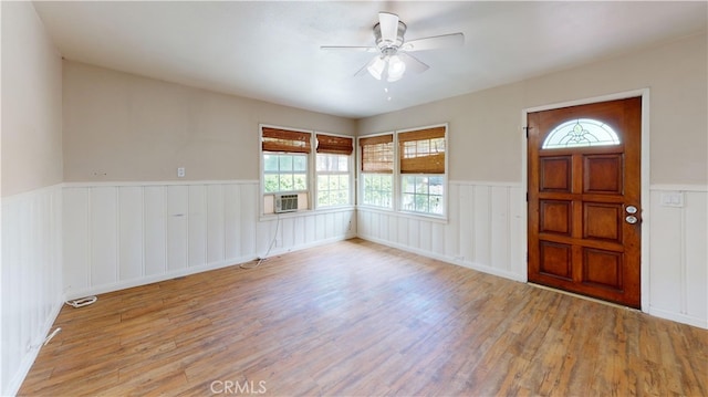 entryway with a ceiling fan, wainscoting, wood finished floors, and a healthy amount of sunlight
