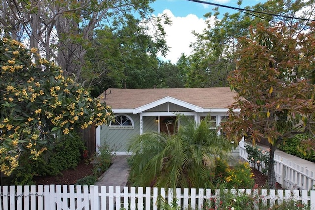 view of front of home featuring fence private yard and roof with shingles