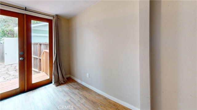 interior space featuring light wood-style flooring, french doors, and baseboards