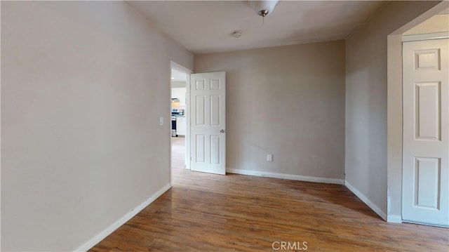 empty room with baseboards and wood finished floors