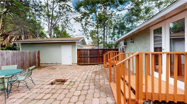 view of patio featuring an outdoor structure, outdoor dining space, and a fenced backyard