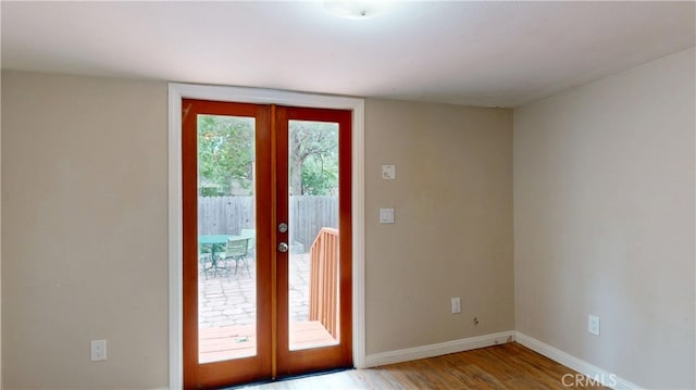 entryway featuring baseboards, light wood-type flooring, and french doors