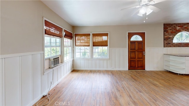 foyer featuring wainscoting, a healthy amount of sunlight, and light wood finished floors