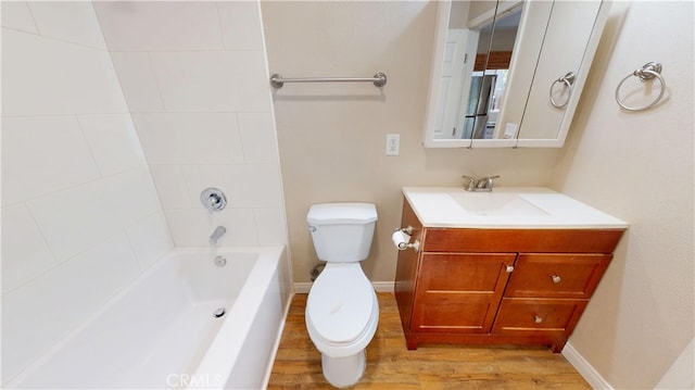 full bathroom featuring wood finished floors, toilet, shower / washtub combination, and vanity