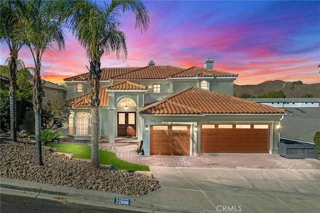 mediterranean / spanish house with a mountain view, french doors, and a garage