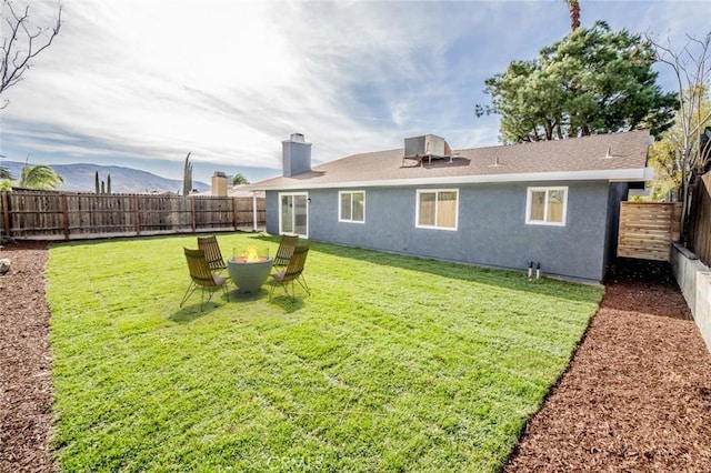 back of property featuring a mountain view and a yard