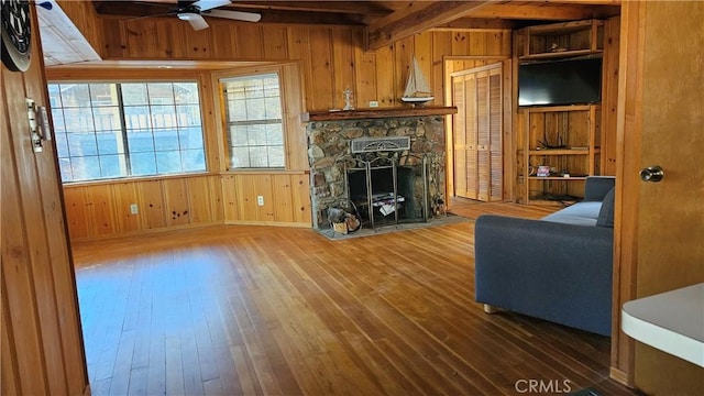 living room with dark hardwood / wood-style floors, ceiling fan, and wooden walls