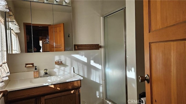 bathroom featuring vanity and a shower with shower door