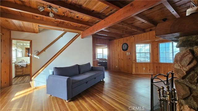 living room featuring hardwood / wood-style flooring, wooden ceiling, beamed ceiling, and wooden walls