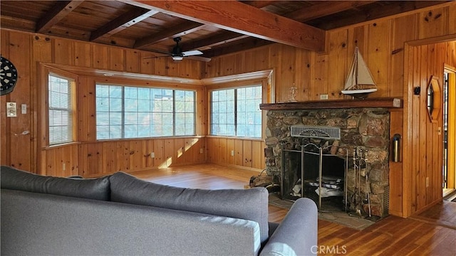 living room with hardwood / wood-style flooring, a stone fireplace, wood ceiling, and beamed ceiling