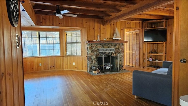 living room with a fireplace, wood walls, hardwood / wood-style floors, and ceiling fan