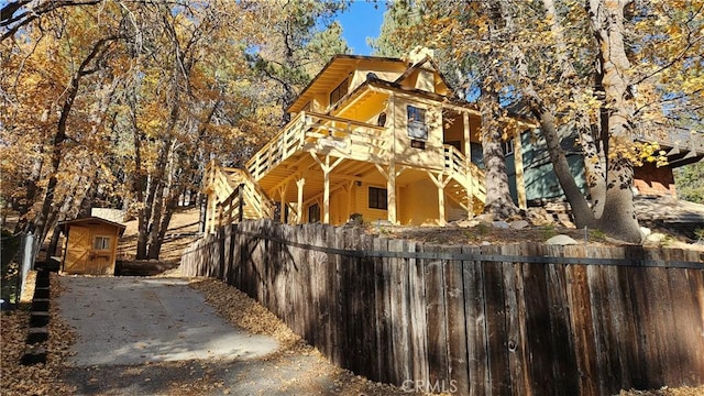 view of home's exterior with a deck and a storage shed