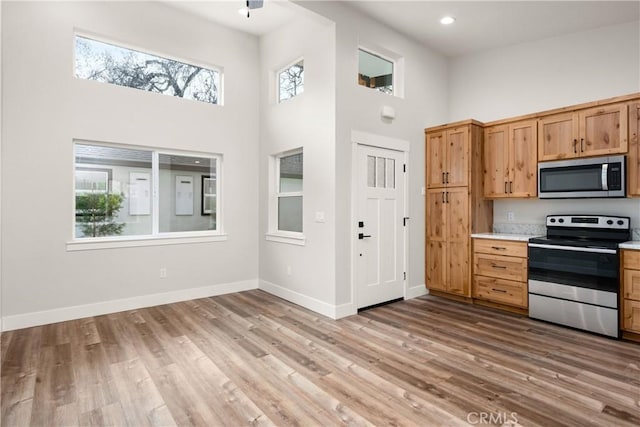 kitchen featuring appliances with stainless steel finishes, light wood-type flooring, and a healthy amount of sunlight