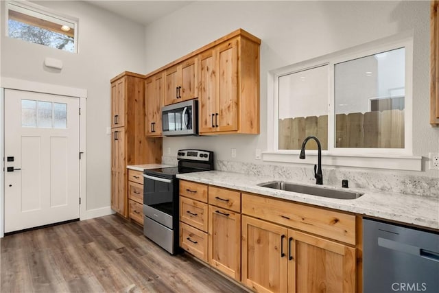 kitchen featuring light stone countertops, stainless steel appliances, dark hardwood / wood-style floors, and sink