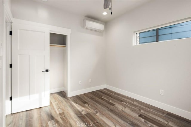 1122 W Sacramento Ave, Chico, CA 95926 - unfurnished bedroom with a wall unit AC, wood finished floors, baseboards, and recessed lighting