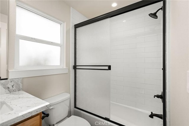 full bathroom featuring vanity, enclosed tub / shower combo, and toilet