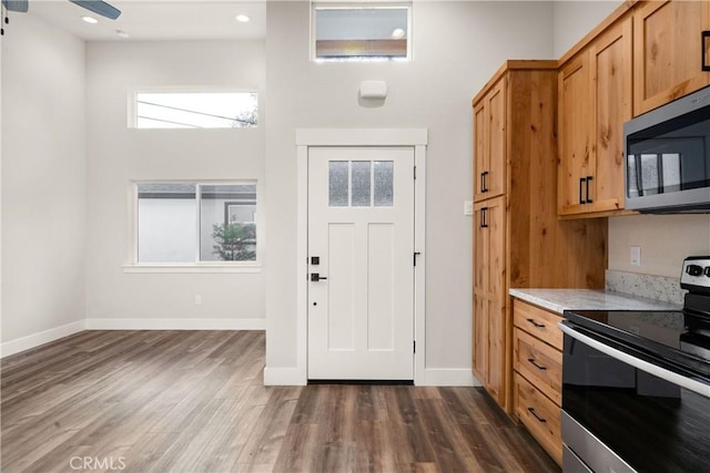 kitchen featuring dark hardwood / wood-style floors, ceiling fan, and appliances with stainless steel finishes