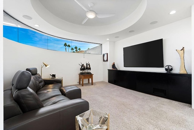 living room featuring carpet flooring, a raised ceiling, and ceiling fan