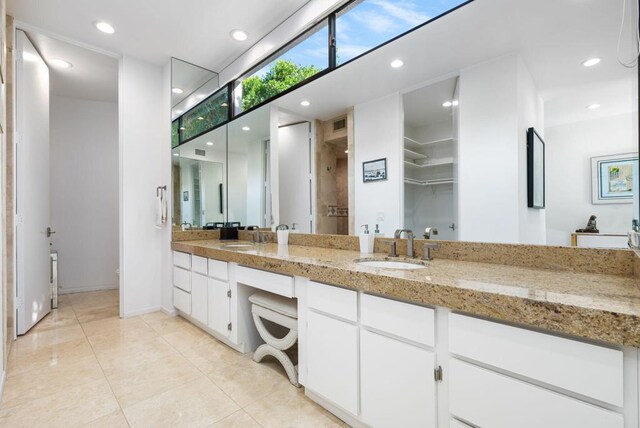 bathroom featuring tile patterned floors, a shower, and vanity