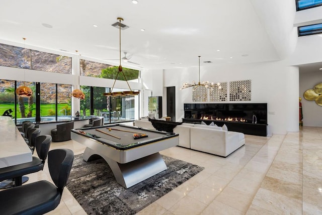 game room featuring a high ceiling, a notable chandelier, and pool table