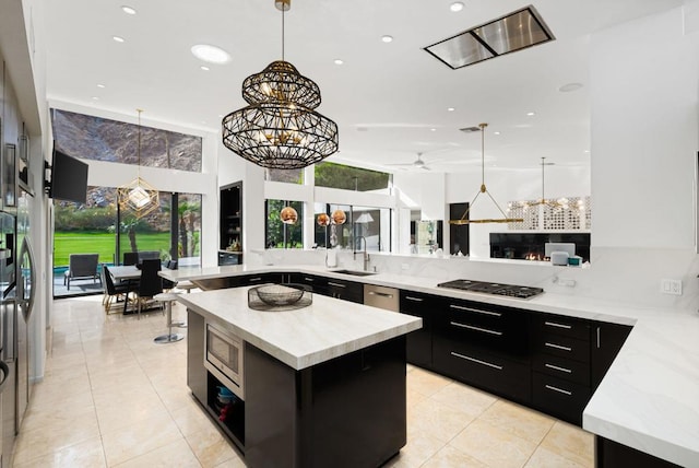 kitchen featuring stainless steel appliances, a large island, plenty of natural light, and pendant lighting