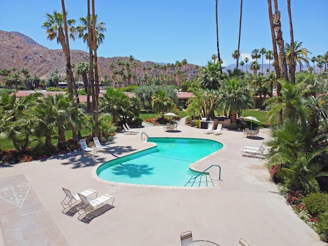 view of swimming pool with a mountain view and a patio area